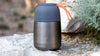 eSeasons Vacuum Insulated Food Flask, elegant Grey with Orange handle: Hot food outdoors set against rugged quarried stone on a hiking tour